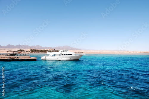 Beautiful white yacht near tropical resort on sunny day © Pixel-Shot
