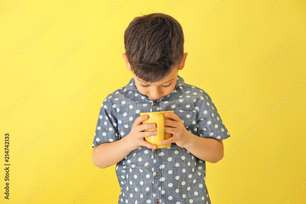 Cute little boy with cup of hot cocoa drink on color background Cute little boy with cup of hot cocoa drink on color background