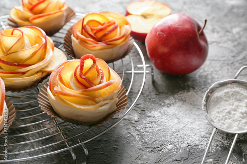 Rack with raw rose shaped apple pastry on table photo