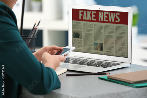 Woman with phone reading ne...