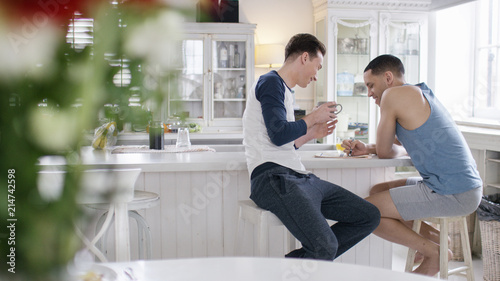 Portrait of male couple relaxing at breakfast in their flat 