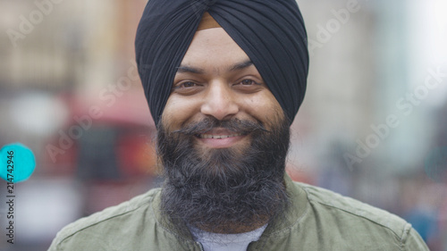 Fototapeta Portrait of smiling Indian male in a turban looking to camera on a street