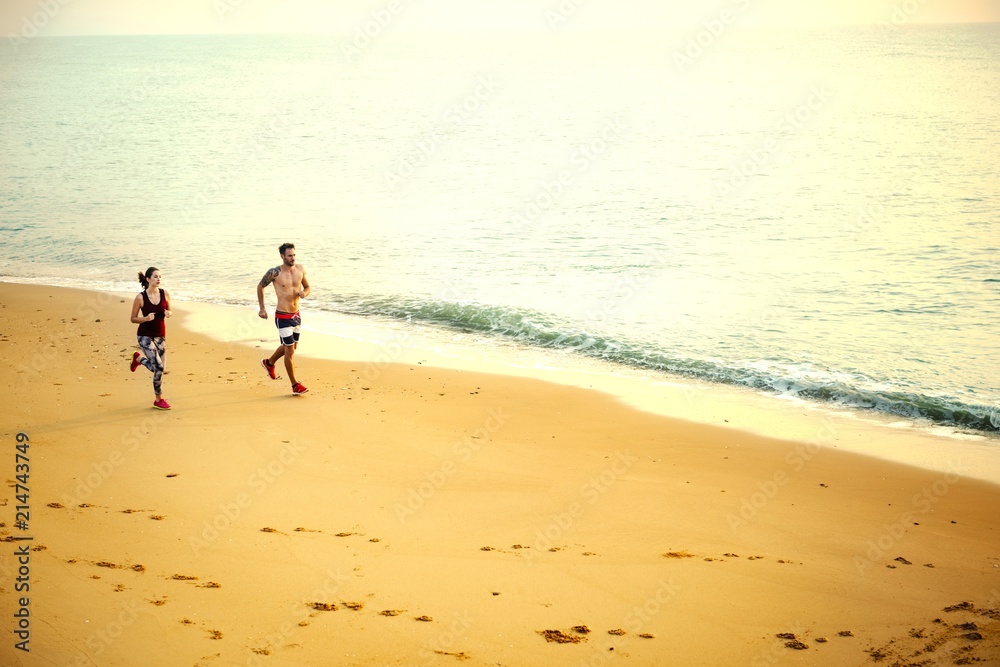 Active couple jogging at the beach