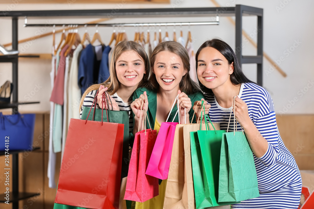 Young beautiful girls with shopping bags in clothing shop Young beautiful girls with shopping bags in clothing shop