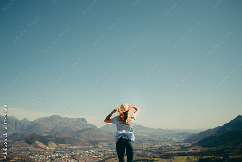 Young woman standing on top of mountain
