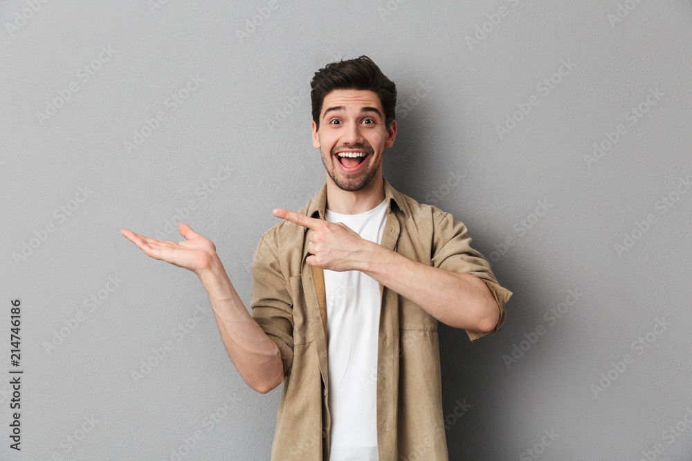 Portrait of a happy young man pointing at copy space Portrait of a happy young man pointing at copy space