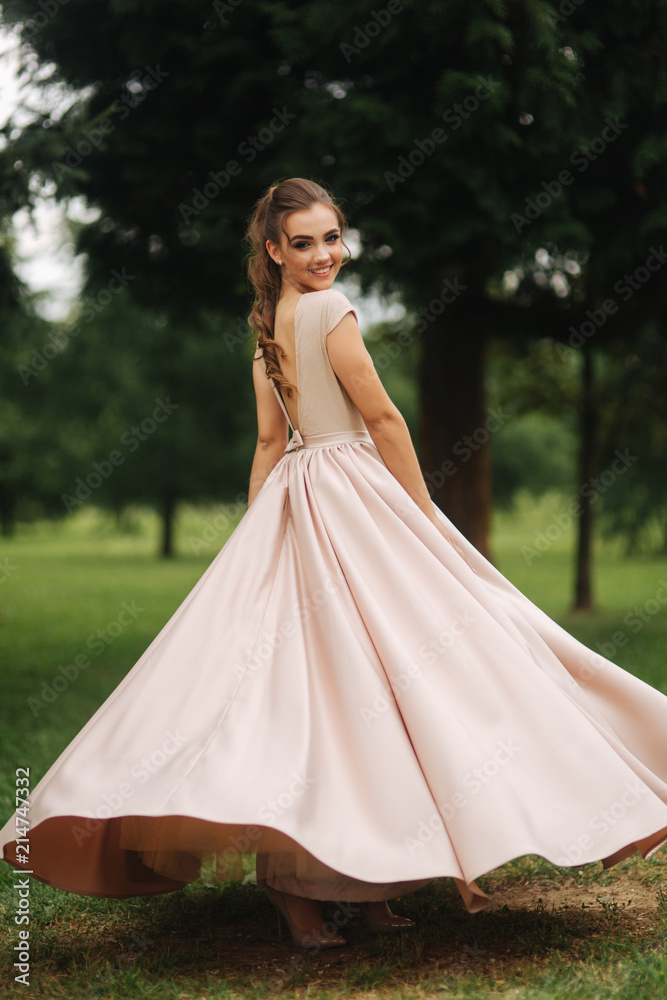 Fashionable girl spin around in park