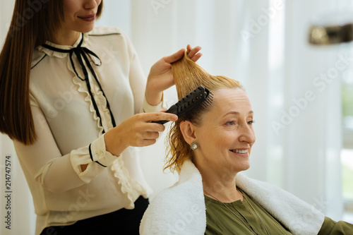 Beauty salon client. Portrait of a positive blonde woman smiling while waiting for a new hairstyle