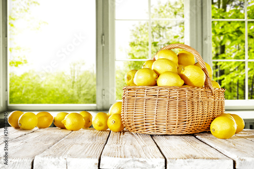fresh yellow lemon on desk and window background with summer garden. Free space for your glass. 