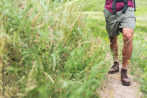 cropped view of tourist walking on path on green field