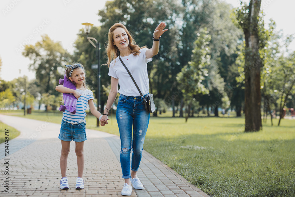 Fototapeta premium Birthday girl. Beautiful stylish mother feeling unbelievably happy while taking her birthday girl to the park