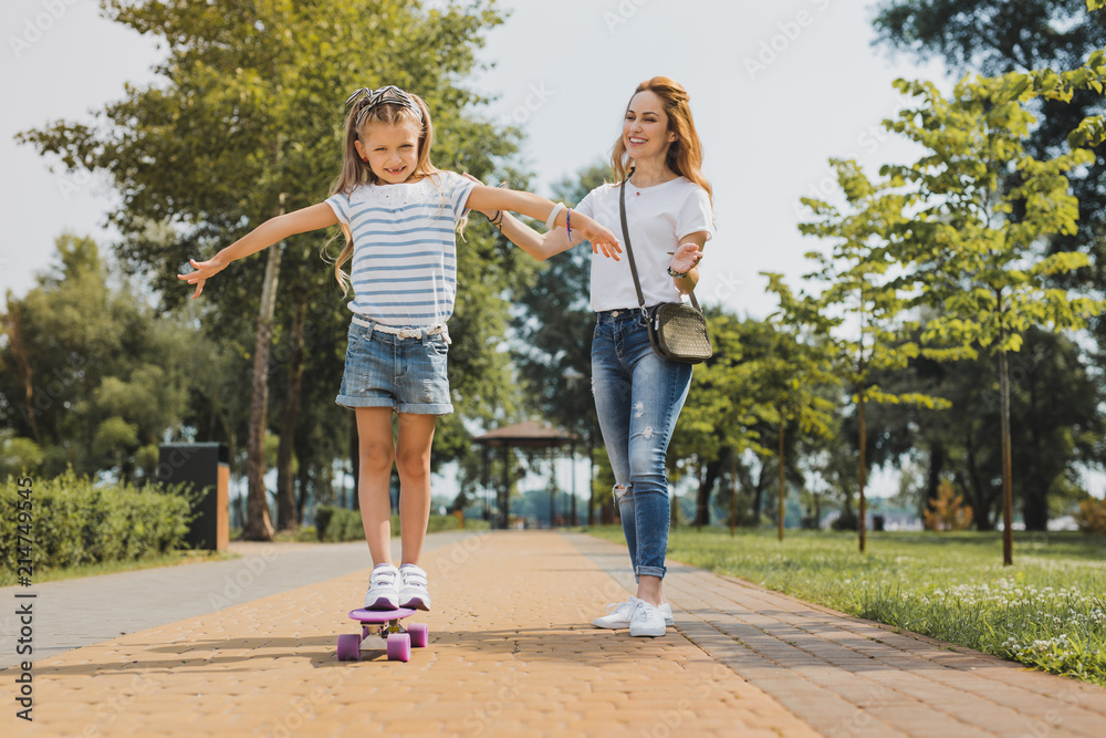 Fototapeta premium Beaming family. Happy beaming family spending their weekend near river in the green nice park