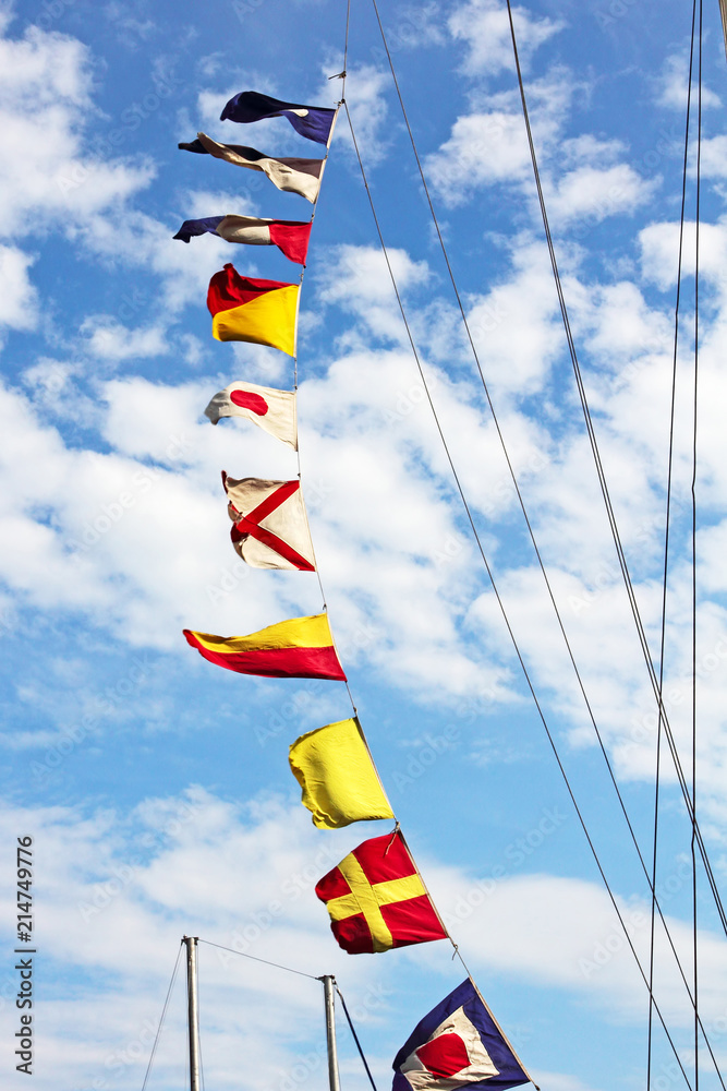 Marine signal flags on a mast against of blue sky. Marine signal flags on a mast against of blue sky.