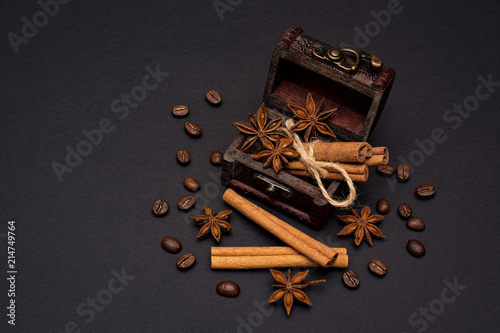 cinnamon sticks, cardamom and coffee beans on a black background top view with copy space for text photo