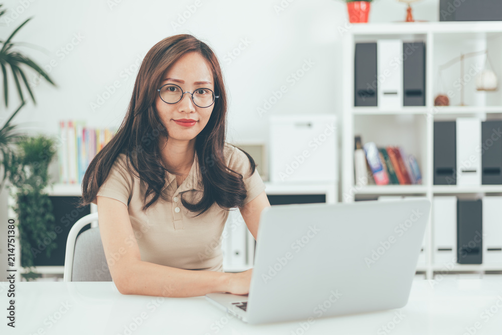 Happy young businesswoman with glasses working on computer laptop in home office Happy young businesswoman with glasses working on computer laptop in home office