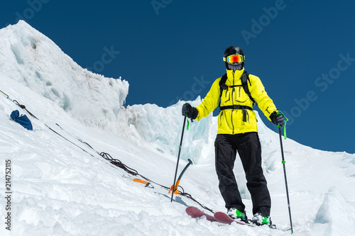 A freerider skier in complete outfit stands on a glacier in the North Caucasus