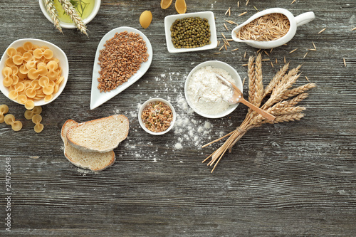 Composition with wheat flour, cereals and pasta on wooden background