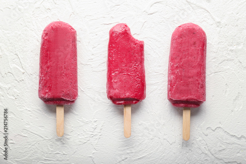 Delicious strawberry popsicles on light background photo