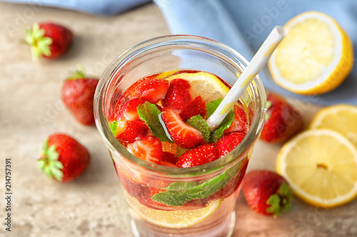 Natural lemonade with strawberries in glass on table
