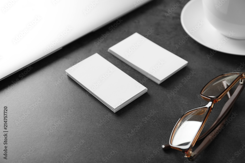 Blank business cards with eyeglasses on grey table Blank business cards with eyeglasses on grey table