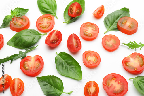 Sliced tomatoes with fresh herbs on white background