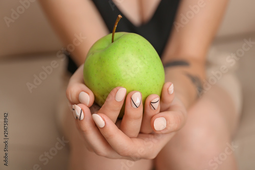 Young woman with stylish manicure holding apple  closeup