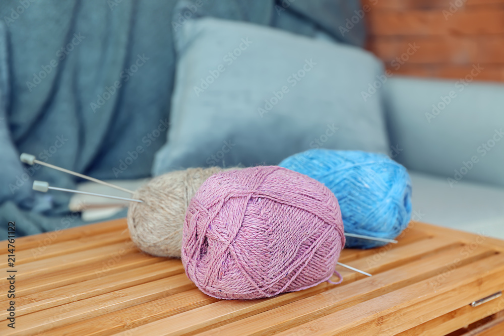 Colorful knitting yarn on wooden crate in room