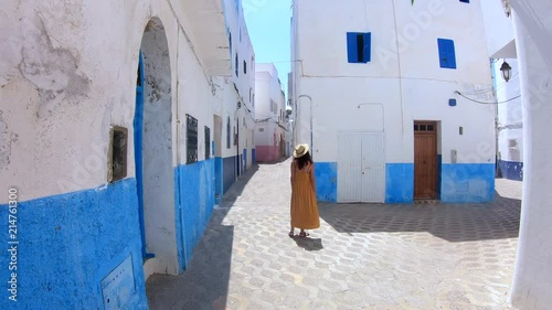 4k Video of a Woman with yellow dress and hat walking in a street of a village in Morocco