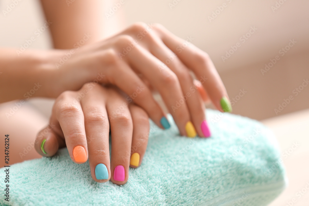 Young woman with colorful manicure in beauty salon, closeup