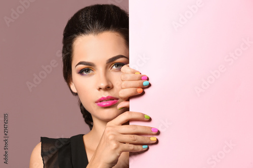 Beautiful young woman with beautiful manicure and blank poster on color background