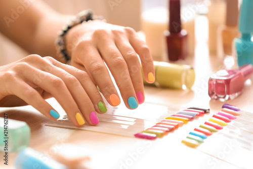 Young woman with colorful manicure in beauty salon