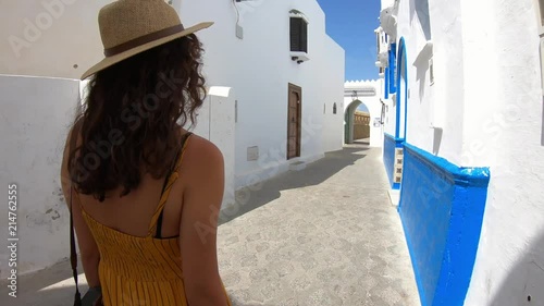 4k Video of a Woman with yellow dress and hat walking in a street of a village in Morocco