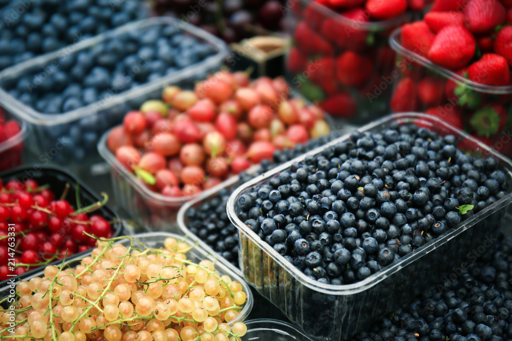 Containers with different ripe berries at market Containers with different ripe berries at market