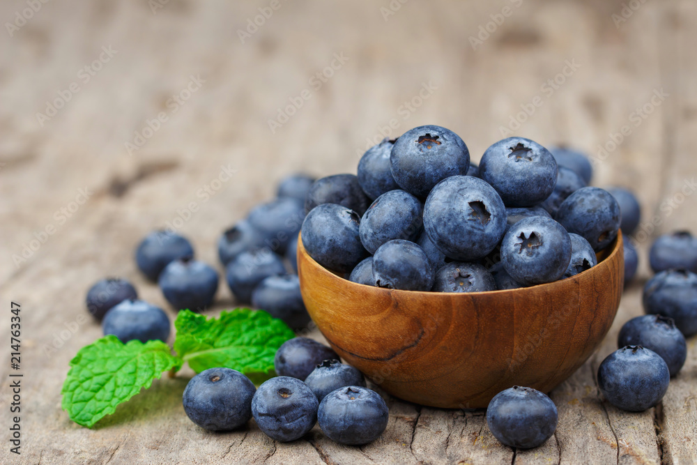 Blueberries in a wood bowl on a wooden table, Healthy eating and nutrition concept Blueberries in a wood bowl on a wooden table, Healthy eating and nutrition concept