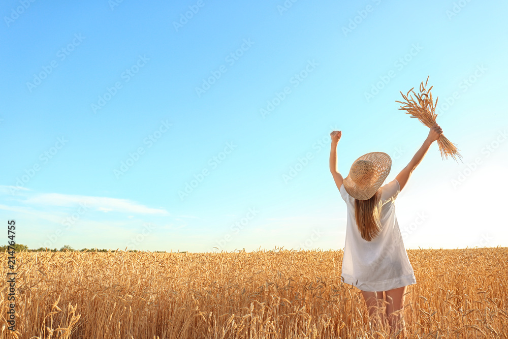 Beautiful woman with wheat spikelets in field on sunny day Beautiful woman with wheat spikelets in field on sunny day