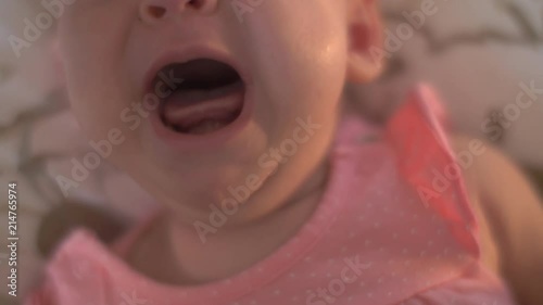 Close-up shot of two months baby girl crying, focus on the open mouth
