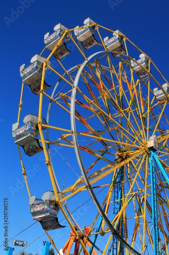 Colorful ferris wheel with bright blue sky background
