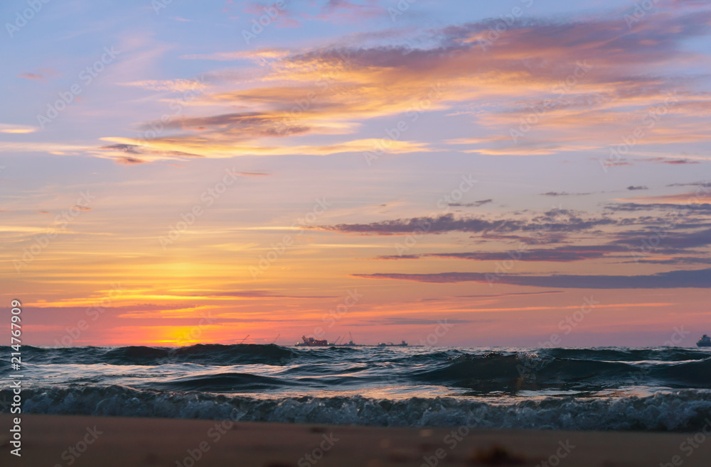 Sunrise in the waves of the sea. Sunset on the sea.