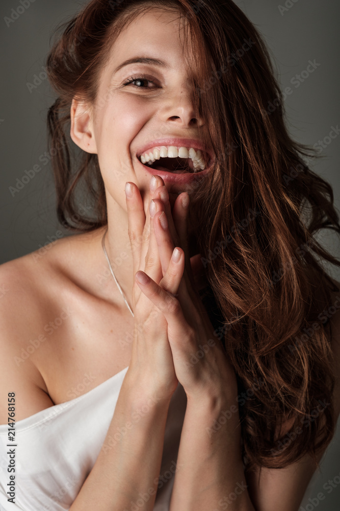 Emotional portrait of a brunette. The girl laughs and looks at the camera. Emotional portrait of a brunette. The girl laughs and looks at the camera.