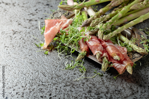 Asparagus wrapped in prosciutto with cress salad .