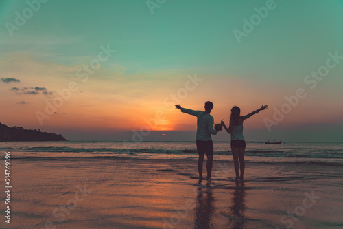 Couple drinking cocnut juice while watching the sunset over the ocean in Bali, Indonesia.