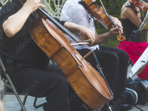 cellist musician group perform music in the street, close up man playing violin