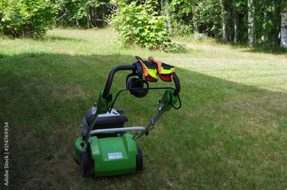 Lawnmower with gloves and ear protection Lawnmower with gloves and ear protection