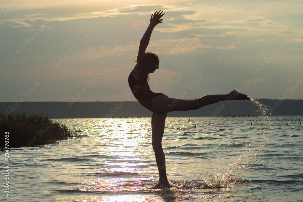 beautiful girl doing gymnastics, yoga, dancing against the background of sunrise, sunset