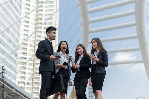 Group of young Urban Businessman and Businesswomen looking at their smartphones and discussing for their project. Technology and internet concept.