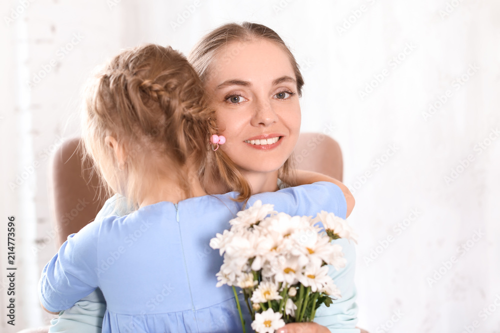 Mother receiving flowers from her cute little daughter at home Mother receiving flowers from her cute little daughter at home