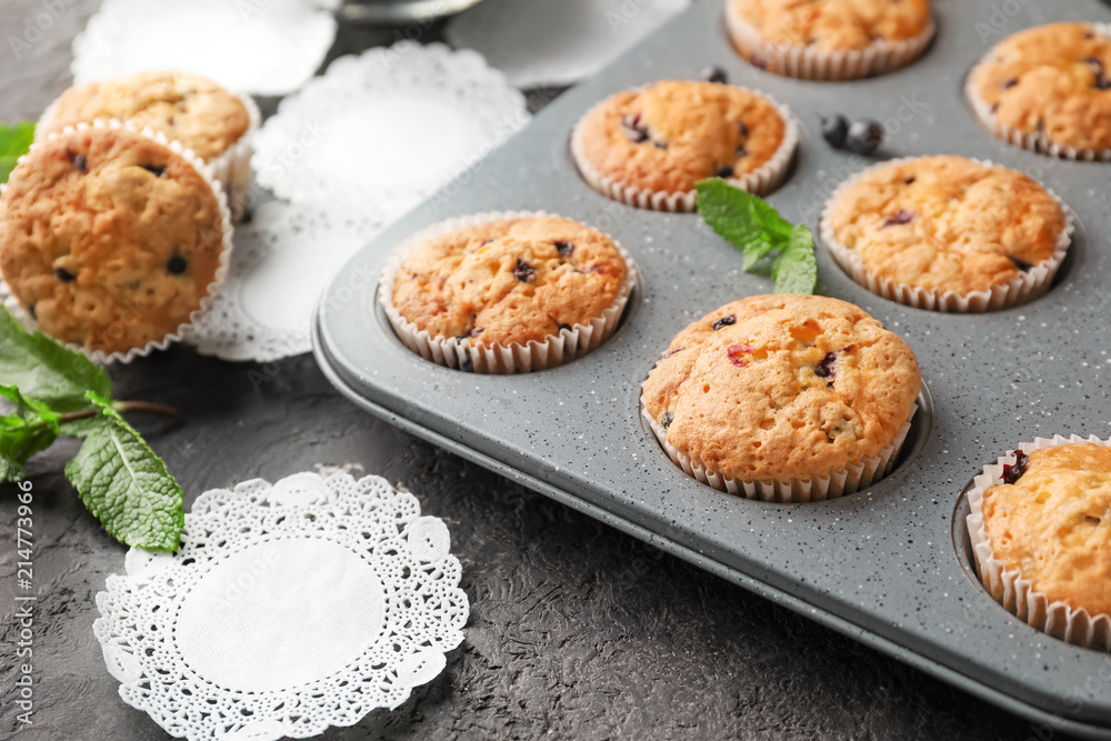 Baking tin with tasty blueberry muffins on table Baking tin with tasty blueberry muffins on table