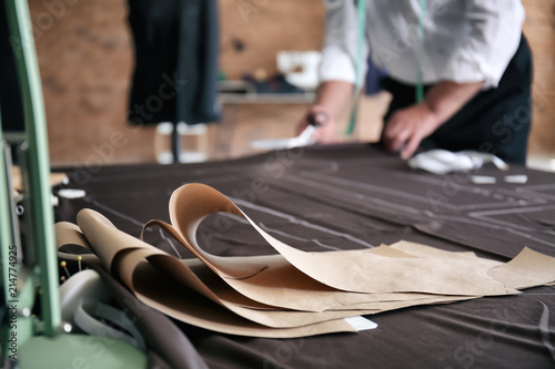 Sewing patterns on fabric in tailor's workshop