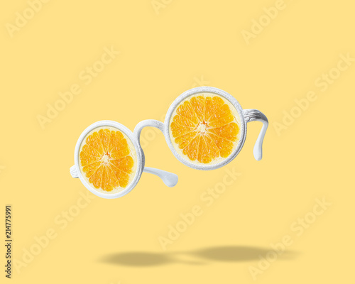 White sunglasses with orange on bright background. Summer minimal concept.