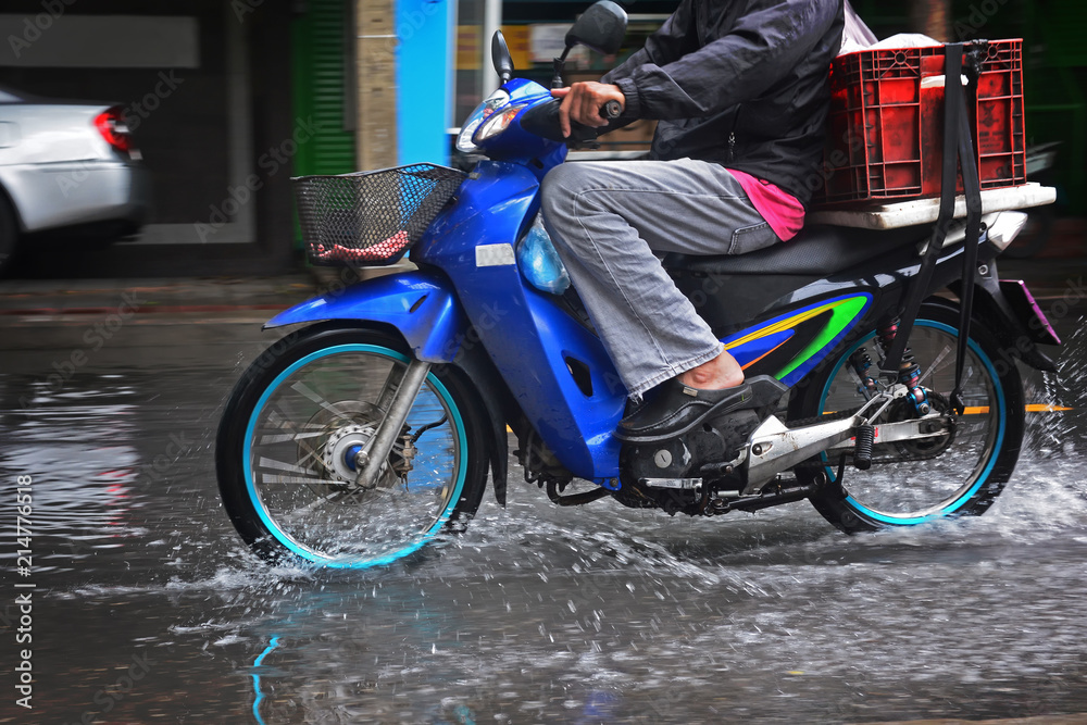 Motorcycle drive through the flood on the road, flooding in Bangkok city, flooding on the road, flooding in the city